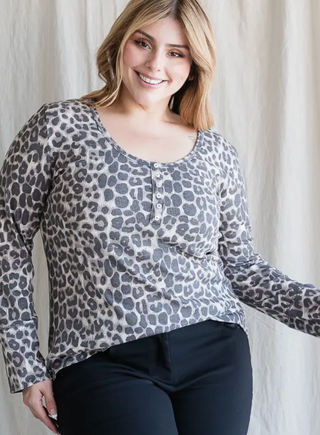 knit top featuring a button front, animal print, top stitch, curved hem, and a long sleeve.
