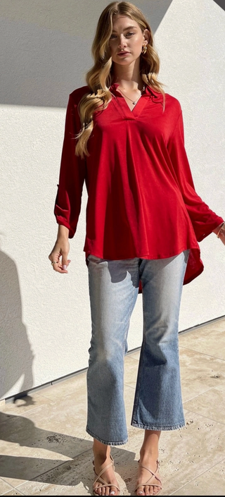 Made from a soft, wrinkle-free poly blend that stays cooler than linen, it’s perfect for travel and everyday wear. Finished with a mandarin collar, 3/4 sleeves with brand new custom gold tabs, and a relaxed high–low silhouette.